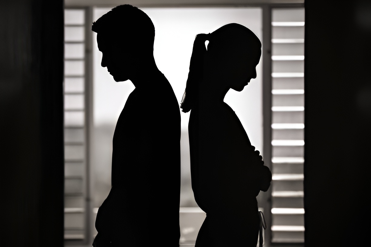 silhouette of a man and a woman, with their backs turned to each other